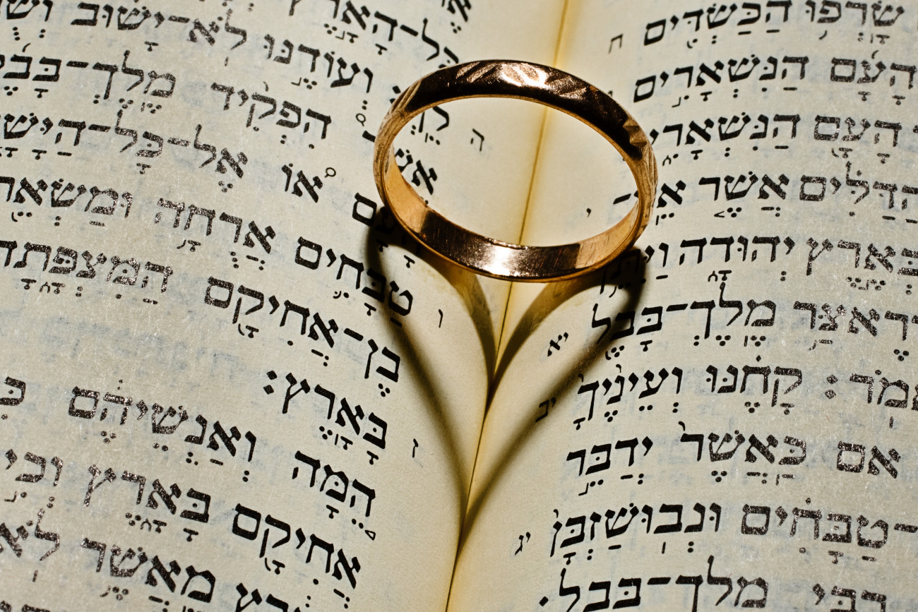 Wedding ring gives the shadow of the heart in the Bible open at the Solomon's Song of Solomon
